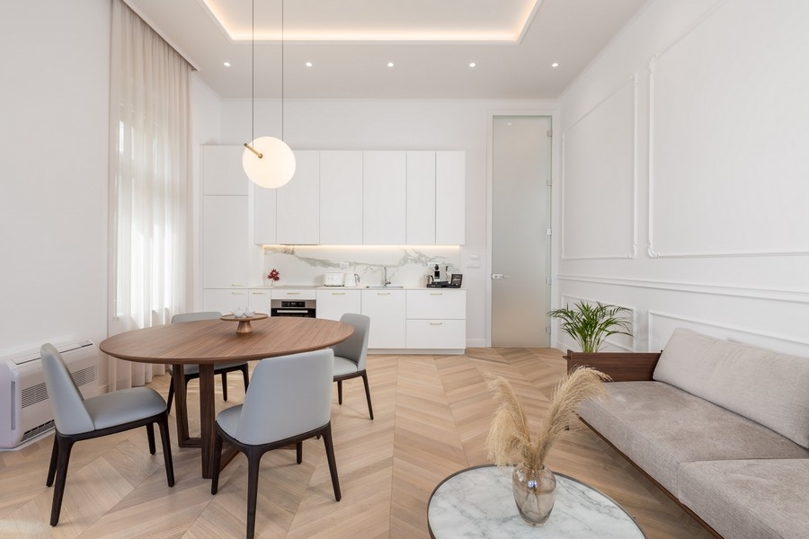 Jasny salon ze stołem jadalnym, krzesłami, kuchnią i sofą