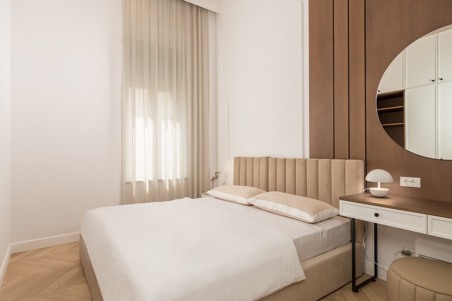 Sypialnia z beżowym łóżkiem i biurkiem