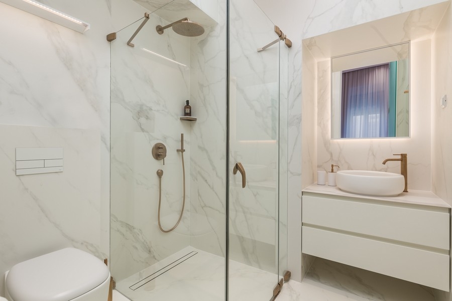 Nowoczesna łazienka ze szklanym prysznicem i marmurowymi płytkami