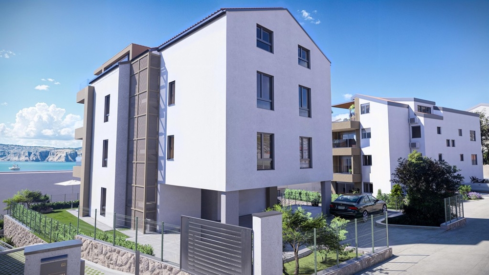 Nowoczesny wielopiętrowy nadmorski budynek mieszkalny z widokiem na morze i utwardzonym parkingiem