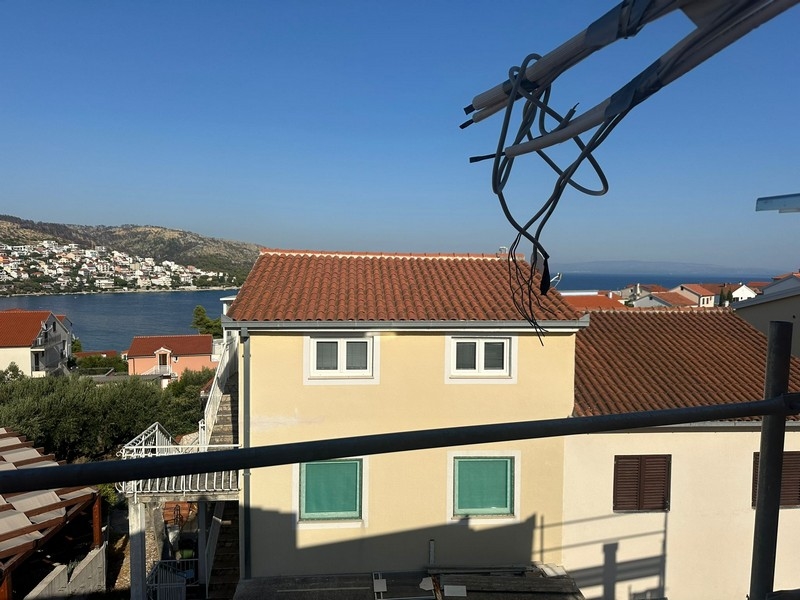 Panoramiczny widok z balkonu w budowie, na sąsiednie domy i linię brzegową ciągnącą się aż po horyzont