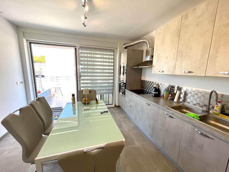 Jadalnia i nowoczesna kuchnia w apartamencie A3387, który jest na sprzedaż w Krk.