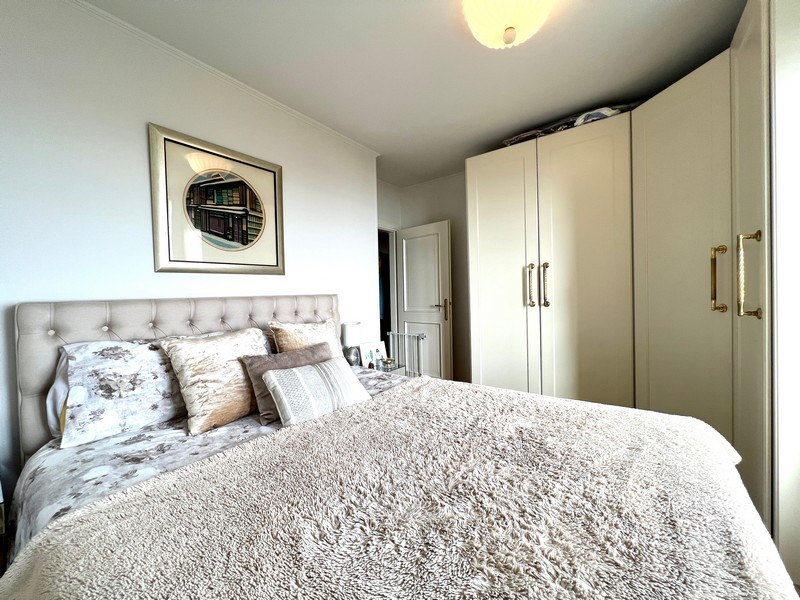 Sypialnia z wyściełanym łóżkiem, miękkimi kocami i wbudowanymi szafami