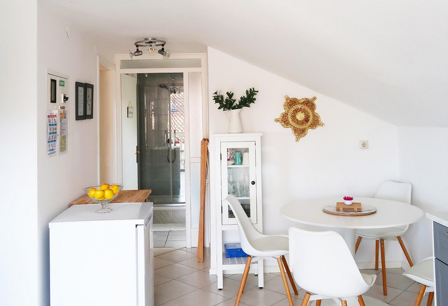 Widok na jadalnię ze stylowym stołem. Tło: łazienka.