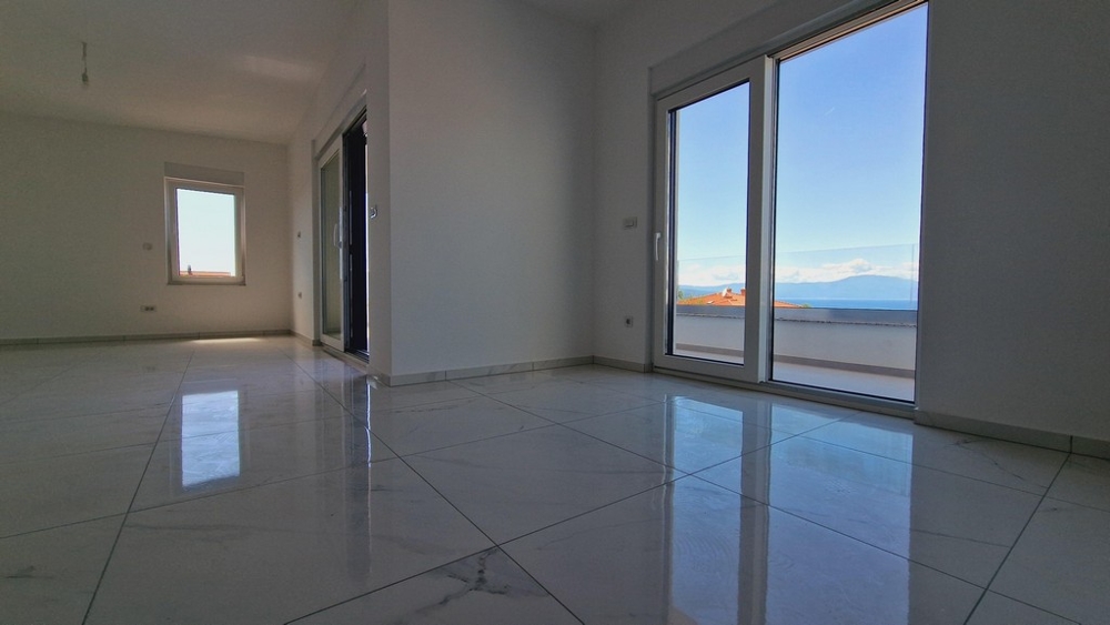 Wnętrze mieszkania z dużymi oknami i widokiem na morze