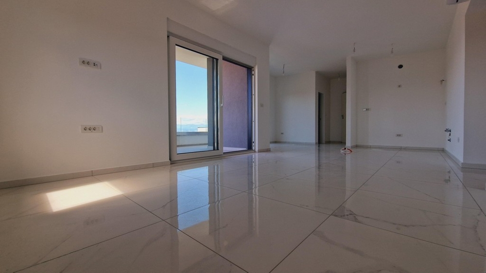 Otwarta część dzienna z dużymi oknami i jasnymi kafelkami