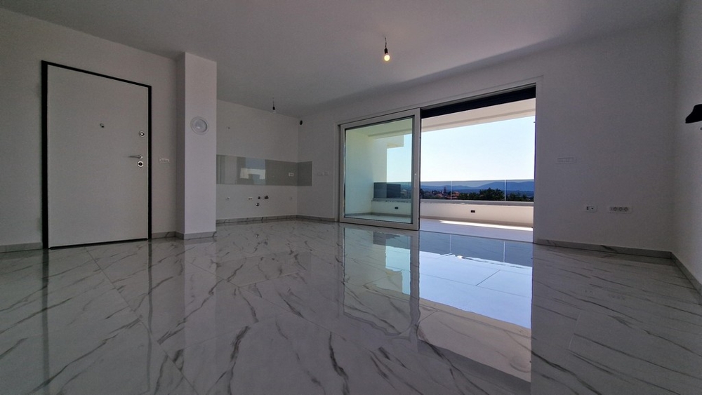 Część dzienna z widokiem na taras i morze, duże drzwi przesuwne.