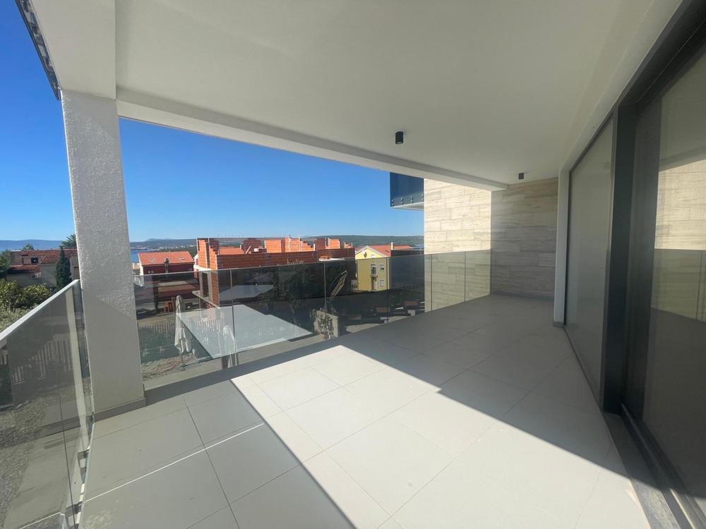 Duży taras z dużymi szklanymi drzwiami i widokiem na morze, podłoga wyłożona kafelkami, stan częściowo wykończony