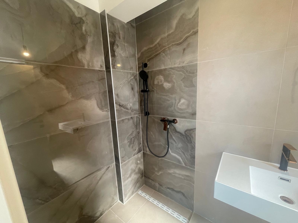 Przestronny, niedokończony pokój z dużymi oknami i ścianami pomalowanymi na biało