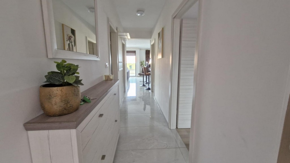 Przedpokój mieszkania z komodą, lustrem i roślinami