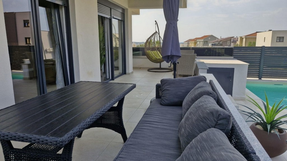 Umeblowany ogród i basen w apartamencie wakacyjnym A3413, który jest na sprzedaż w Chorwacji w Novalji.