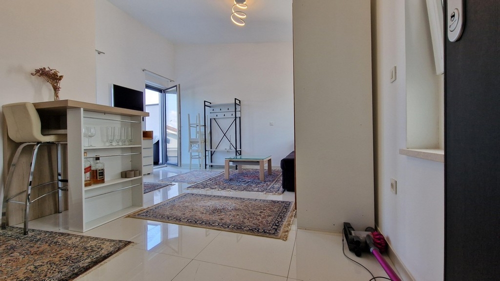 Nowoczesna strefa wejściowa ze stołkami barowymi i bieżnikami dywanowymi, widok na salon i taras.