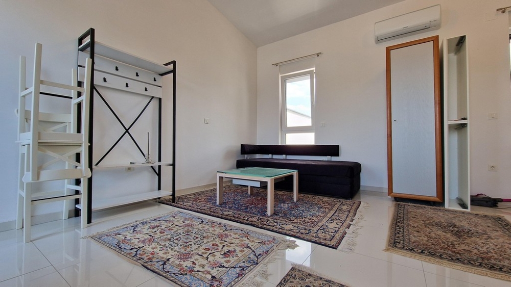 Pokój dzienny z sofą, dywanami i klimatyzacją, nowoczesny i jasny styl.