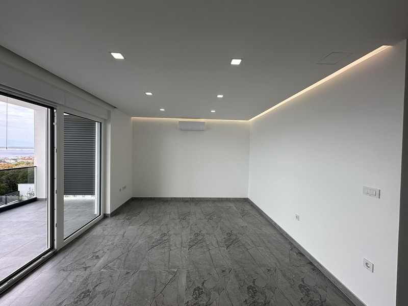 Pokój dzienny z dużymi oknami i widokiem na taras i morze