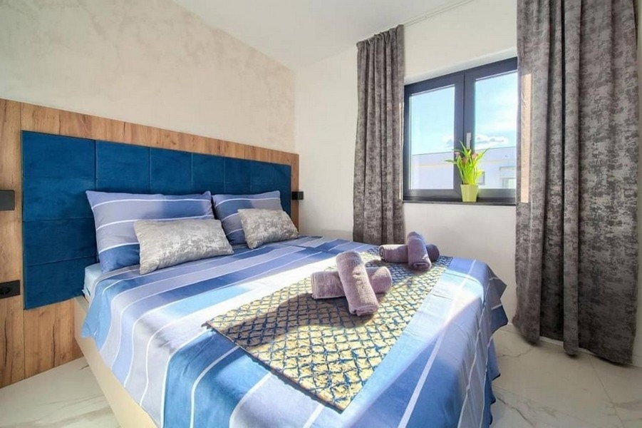 Nowoczesna sypialnia z dużym łóżkiem i oknami