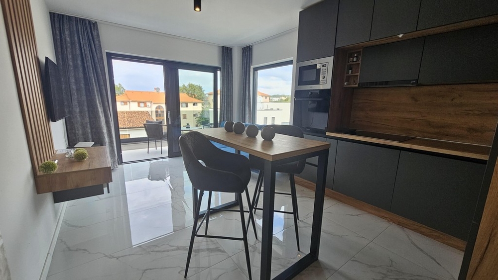 Otwarta kuchnia i jadalnia z balkonem i dużym oknem od frontu