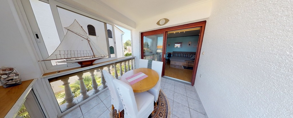 Taras i widok na część dzienną apartamentu wakacyjnego A3458, który jest sprzedawany w Chorwacji.