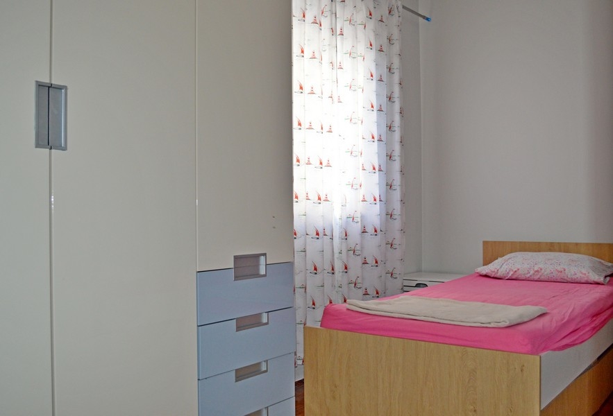 Mniejsza sypialnia z łóżkiem pojedynczym.