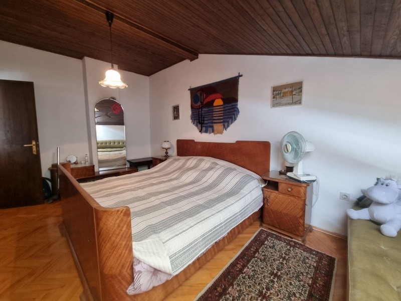 Sypialnia z dużym łóżkiem, drewnianym sufitem i dywanem.