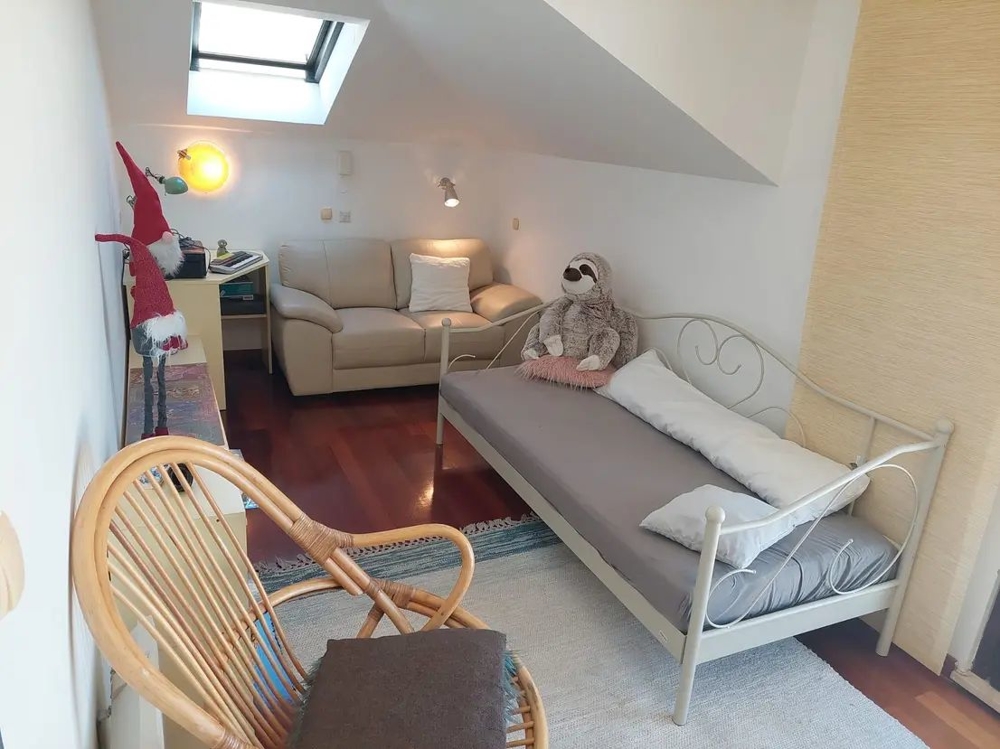 Pokój z sofą, świetlikiem, łóżkiem i dekoracjami