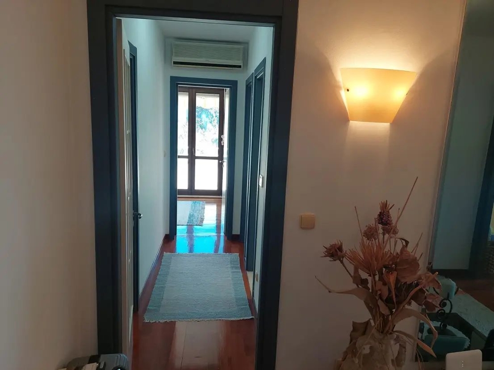 Przedpokój z jasnymi ścianami i drewnianymi podłogami, nowocześnie umeblowany obszar wejściowy