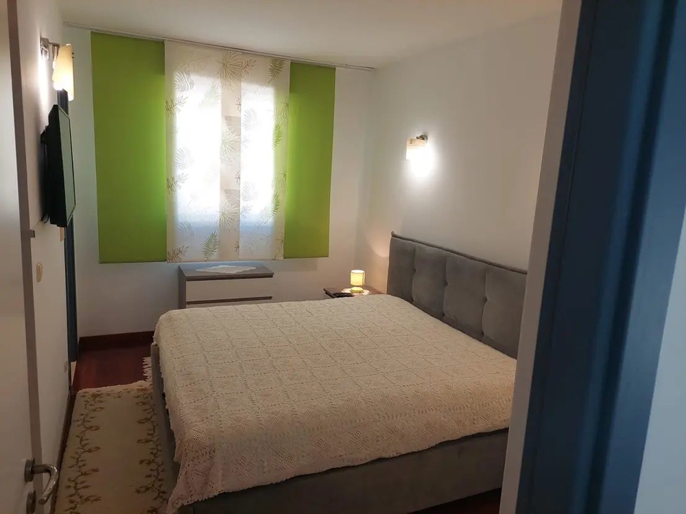 Sypialnia z dużym łóżkiem i zielonymi zasłonami