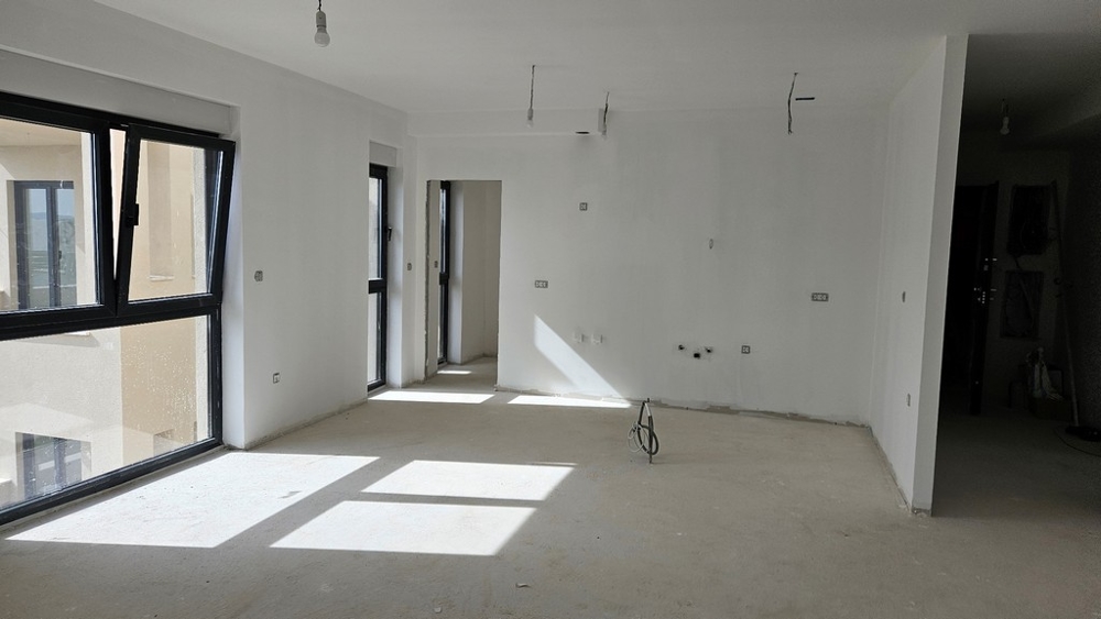 Niewykończone wnętrze z dużą ilością naturalnego światła, do którego dostęp zapewniają duże okna