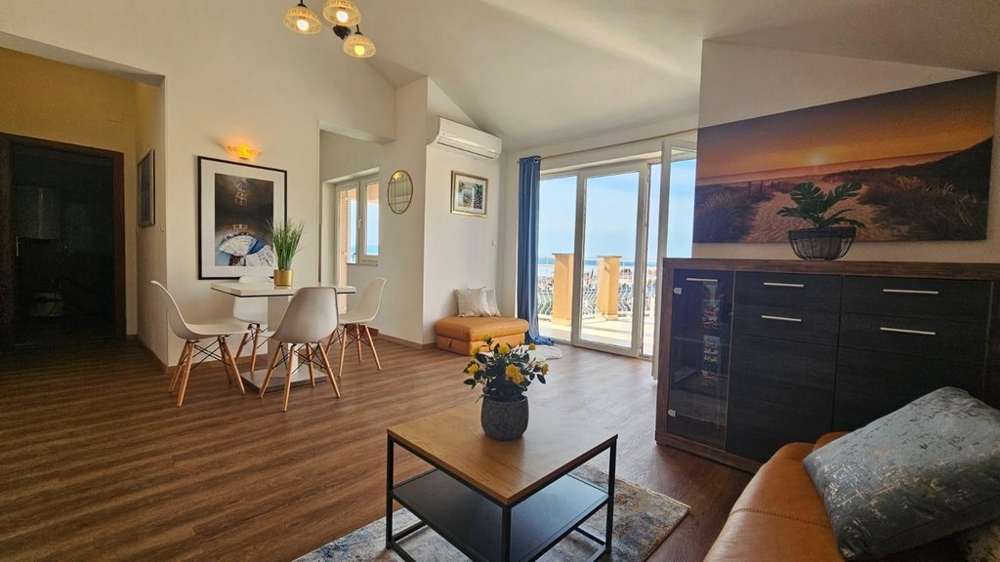 Część dzienna z jadalnią i wyjściem na taras, ozdobiona roślinami i freskami