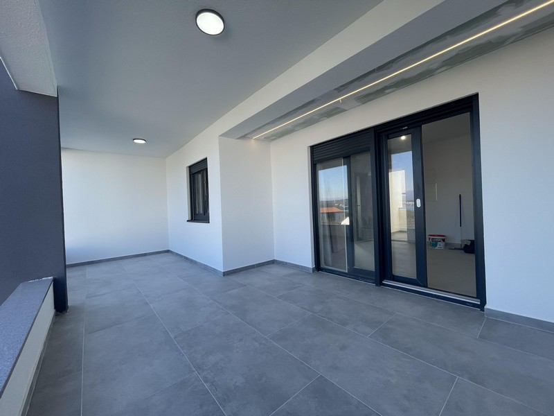 Duży taras z podłogą wyłożoną kafelkami i oświetleniem