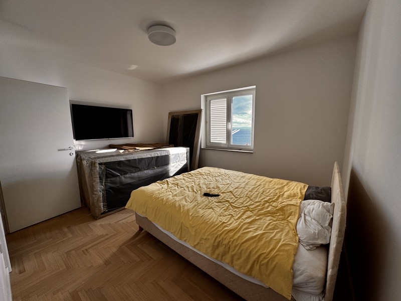 Sypialnia z tapicerowanym łóżkiem, drabiną i otwartą przestrzenią na ścianie