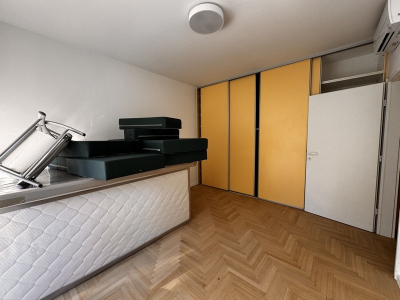 Pokój z żółtymi drzwiami szafki, ułożonymi materacami i klimatyzacją