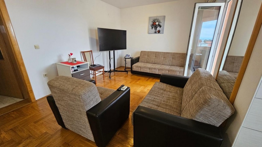 Umeblowany salon z wyjściem na taras w mieszkaniu na sprzedaż w Malinskiej (Chorwacja).