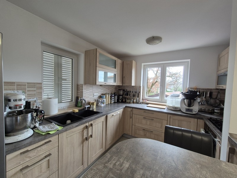 Nowoczesna kuchnia z drewnianymi frontami i widokiem na zewnątrz