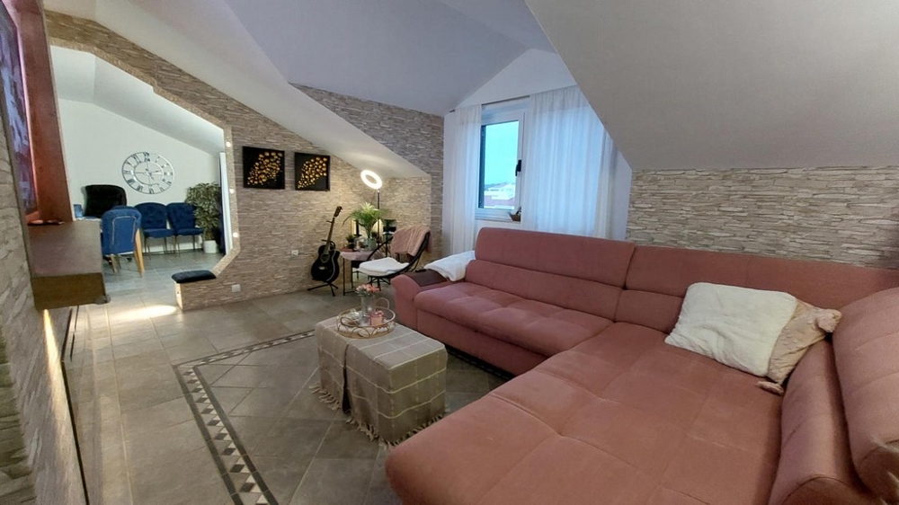 Przestronny salon z kanapą i widokiem na stół jadalny.