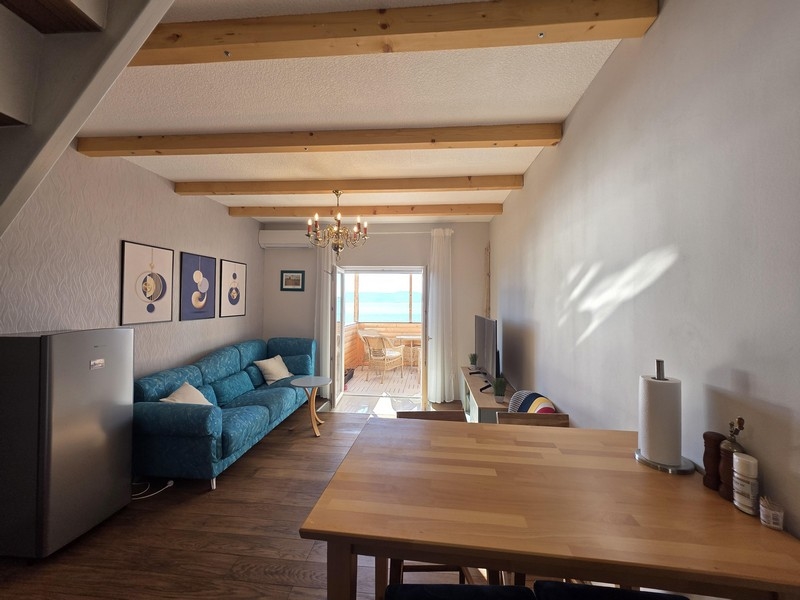 Część dzienna z sofą i widokiem na morze z balkonu