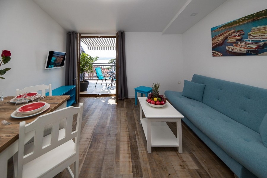 Pokój dzienny z wyjściem na balkon i widokiem na morze