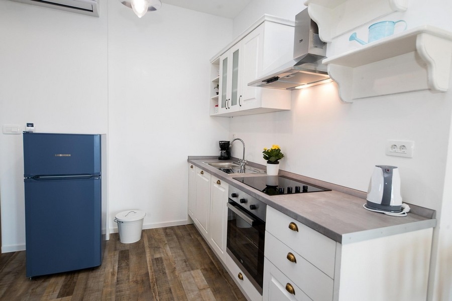 Kuchnia z niebieskimi akcentami i podłogą z twardego drewna