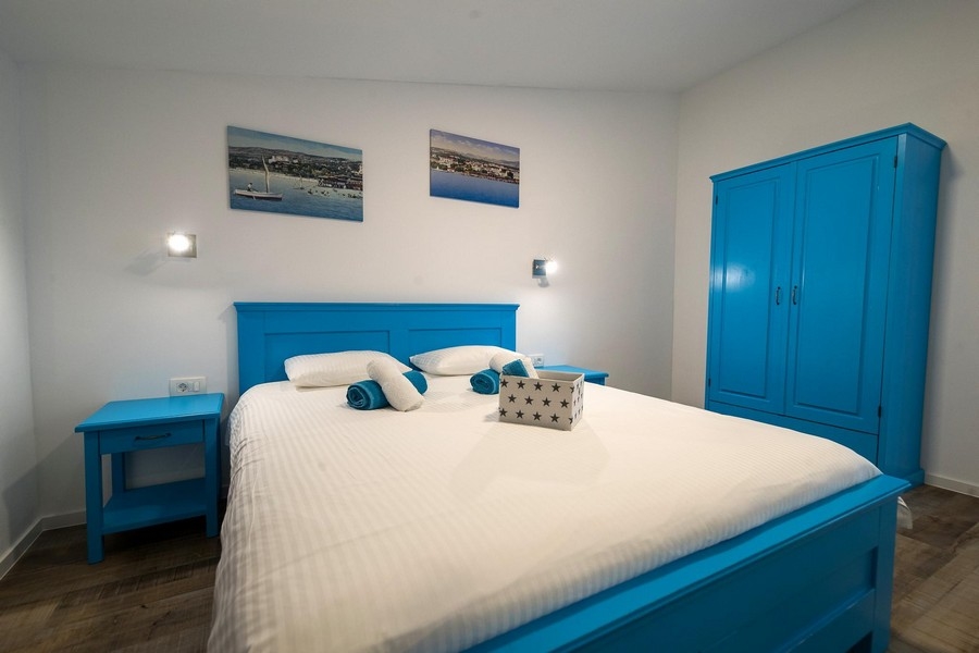 Sypialnia z niebieskim łóżkiem i szafą