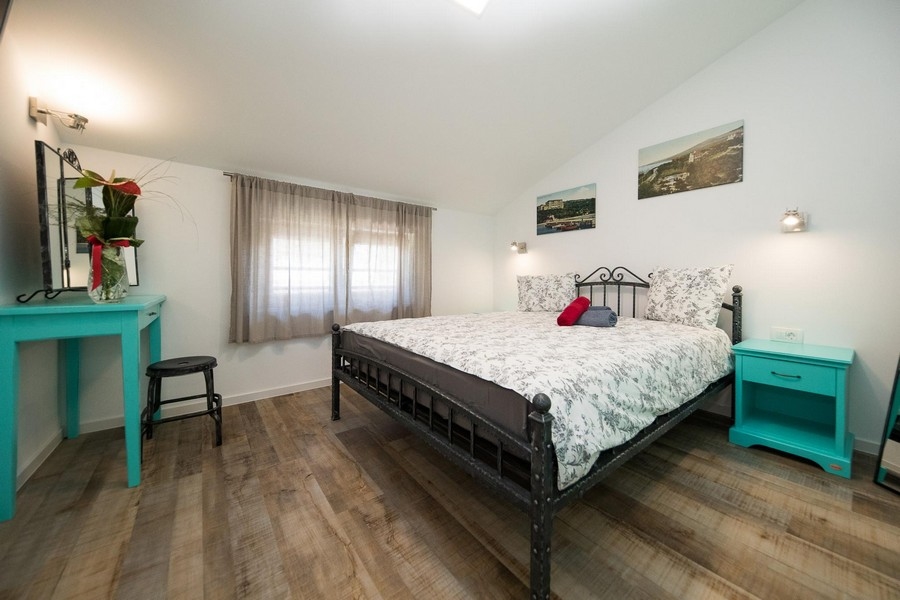 Sypialnia z zieloną szafką i toaletką