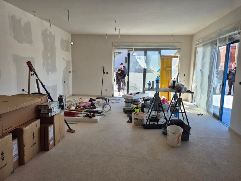 Część dzienna z materiałami budowlanymi i wyjściem na taras