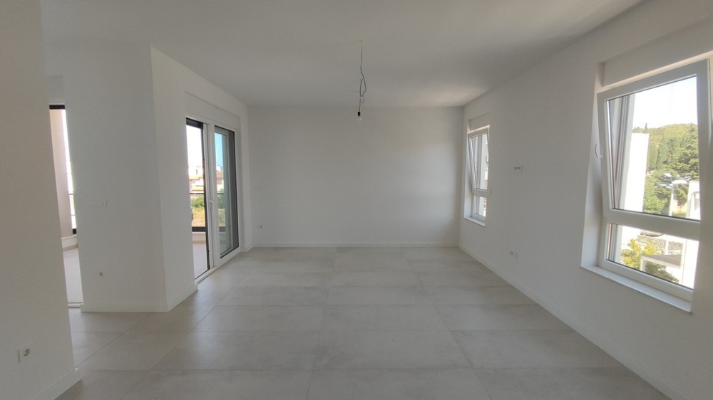 Widok na tył nowego budynku i miejsca parkingowe.