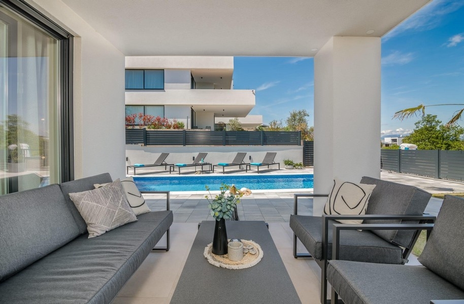 Taras z widokiem na basen i leżakami