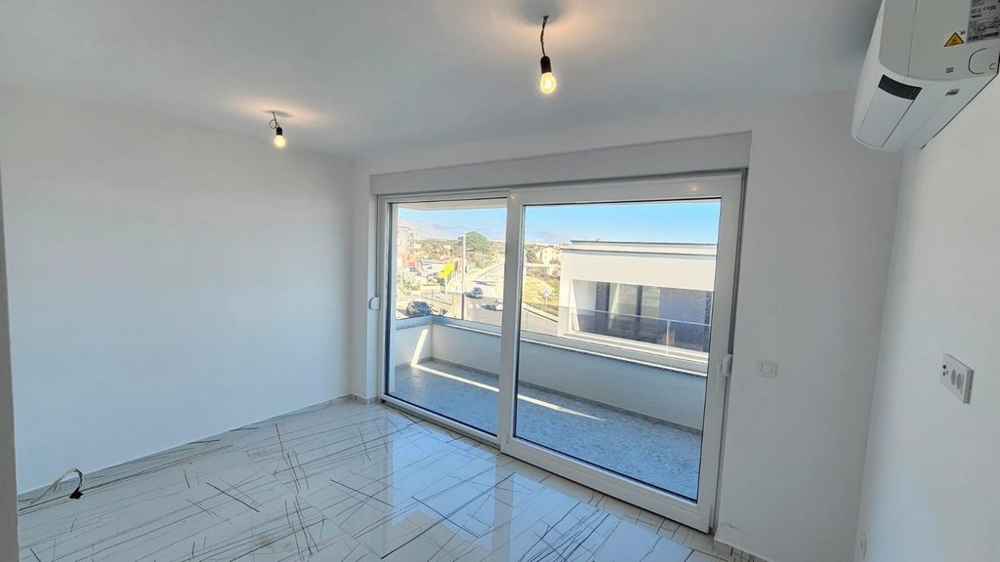 Druga sypialnia z wyjściem na balkon i widokiem na osiedle mieszkaniowe