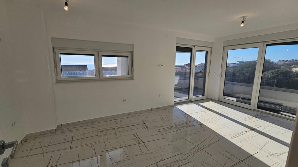 Jasny salon z dużymi oknami i wyjściem na balkon