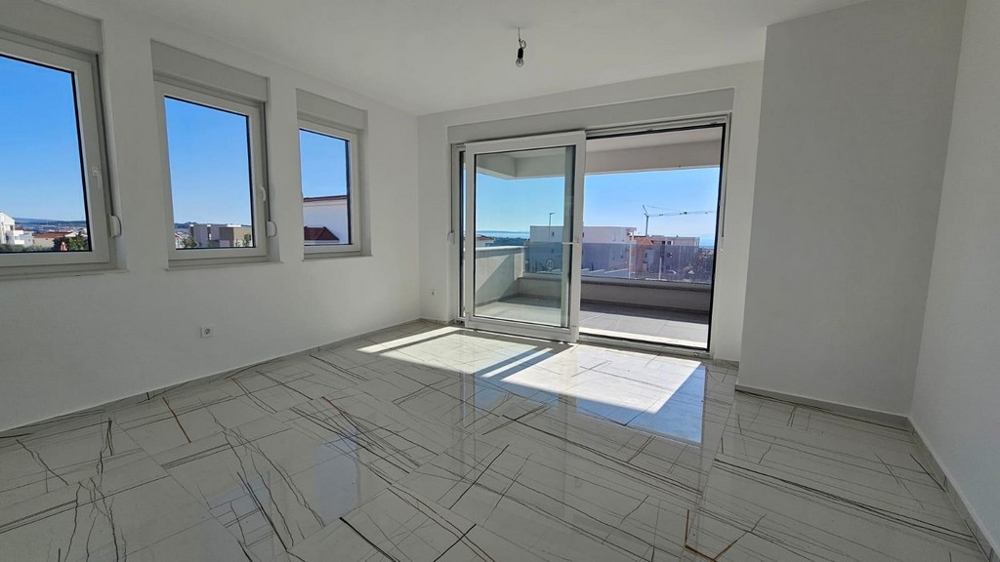 Jasny salon z balkonem i widokiem na morze.