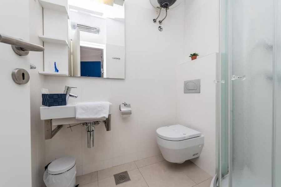 Łazienka z prysznicem i białymi płytkami