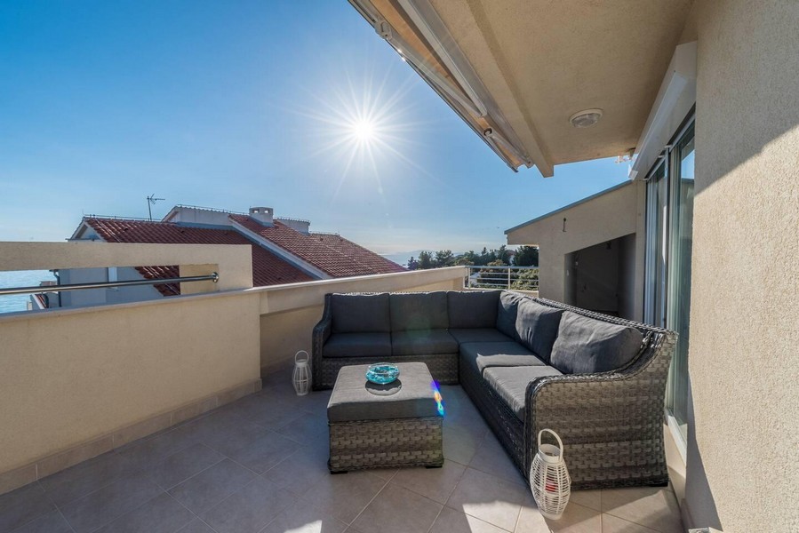 Słoneczny taras na dachu z częścią wypoczynkową i widokiem na morze