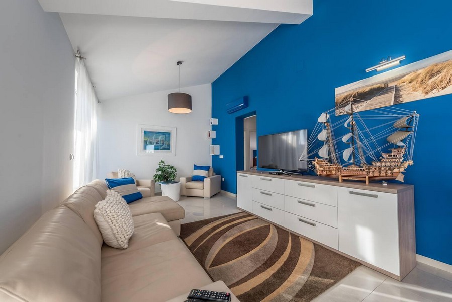 Przytulny salon z dużą kanapą i telewizorem