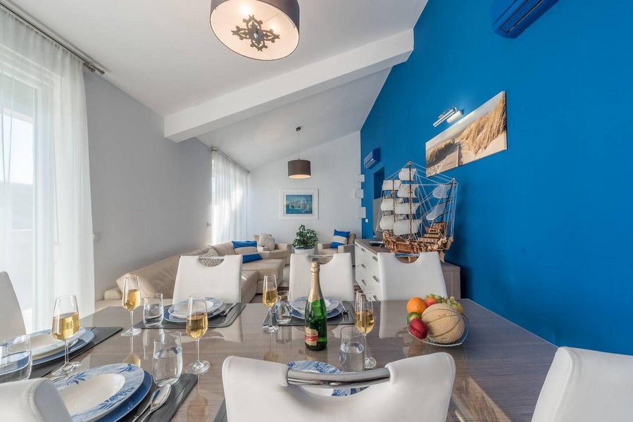 Część jadalna z nakrytym stołem i widokiem na salon