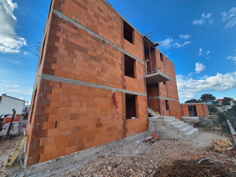 Widok z tyłu stanu surowego z klatką schodową i ścianami nieotynkowanymi